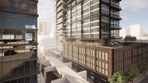 Two apartment towers next to an elevated train tracks. 