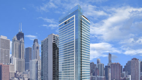 A glassy high-rise surrounded by other tall buildings.