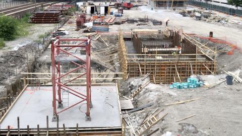 Construction crews work on a foundation and tower crane base. 