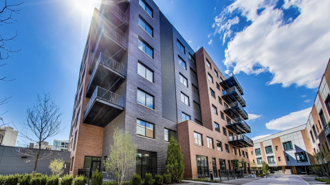 A seven-story condo development next to townhomes. 